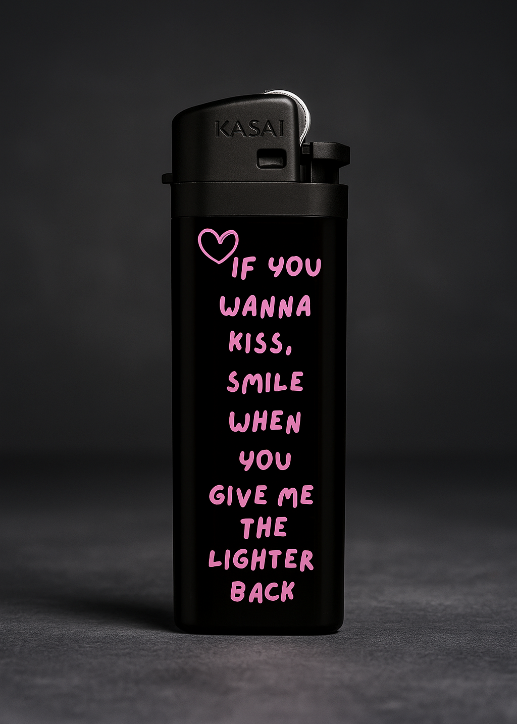 Parmaklar arasında yakılırken görünen siyah çakmak, üzerinde pembe kalp sembolü ve “If you wanna kiss” yazılı tasarım metni bulunan banner görseli.